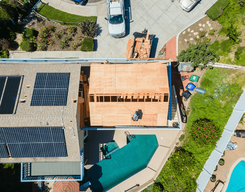 Aerial top-down view of an ADU under construction adjacent to solar-equipped roof, illustrating site planning and shading strategy.