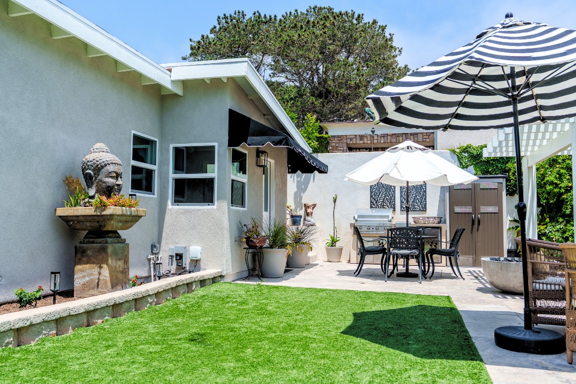 Modern detached ADU with outdoor patio and dining area under striped umbrellas