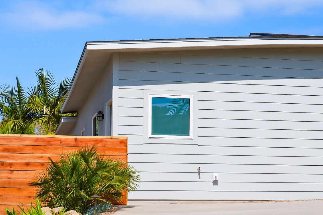 Detached ADU exterior with light gray siding and wood privacy fence