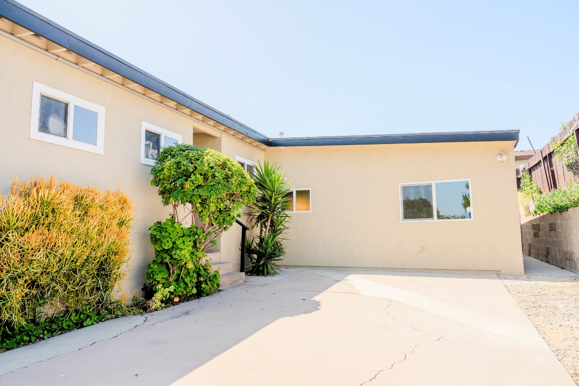 Single-story ADU with beige stucco exterior and driveway landscaping