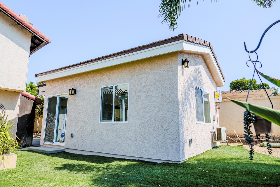 Small backyard ADU with sliding door and stucco finish