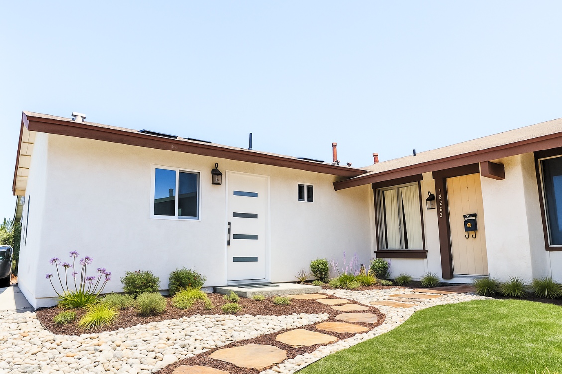 Contemporary ADU entry with stone walkway, landscaping, and white stucco exterior