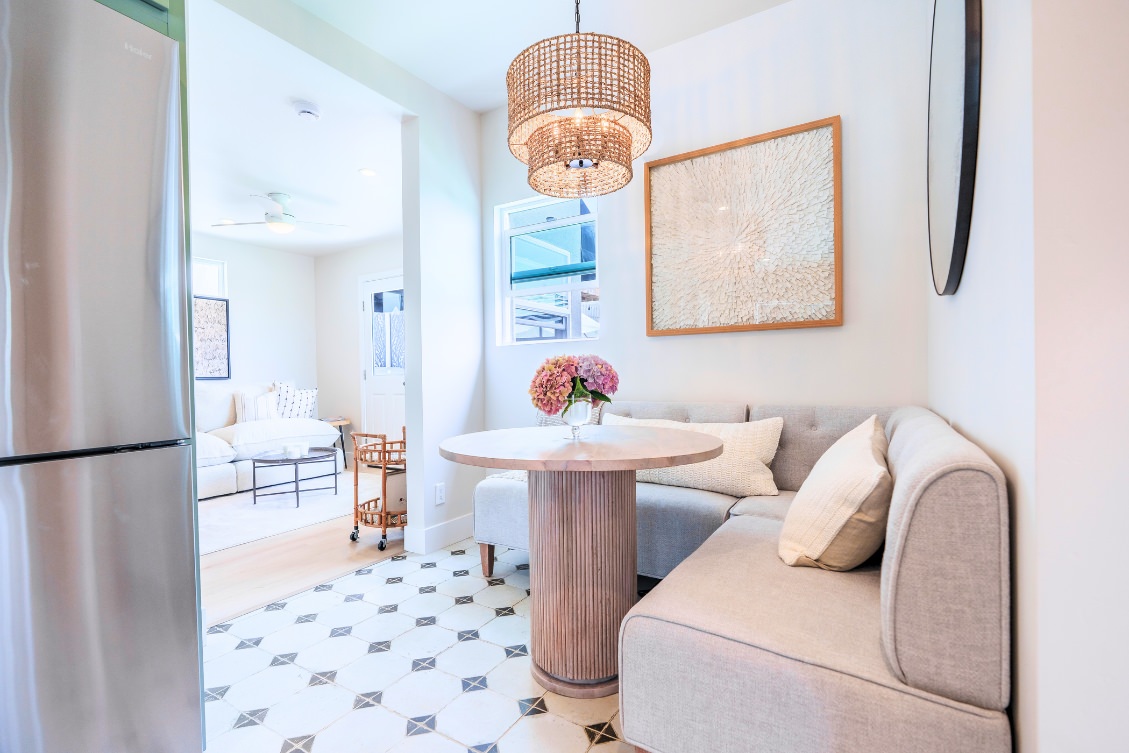 Small ADU kitchen nook with built-in banquette seating and woven pendant light
