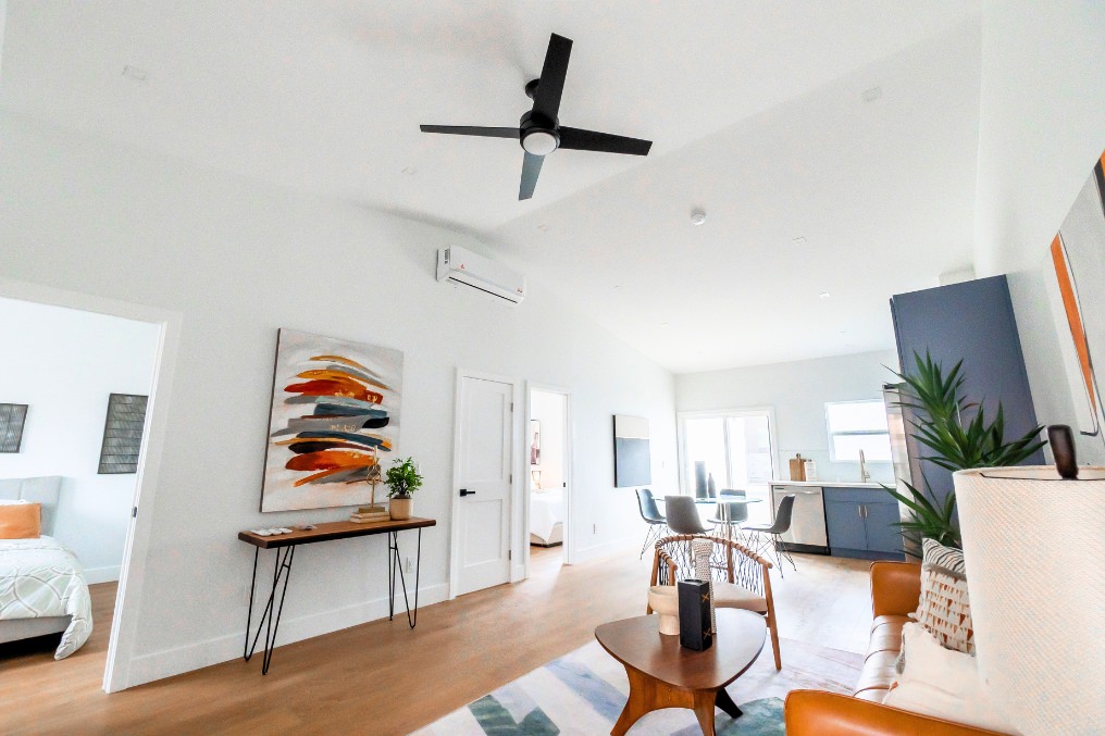 Spacious ADU open-concept living room with vaulted ceiling, modern art, and dining area