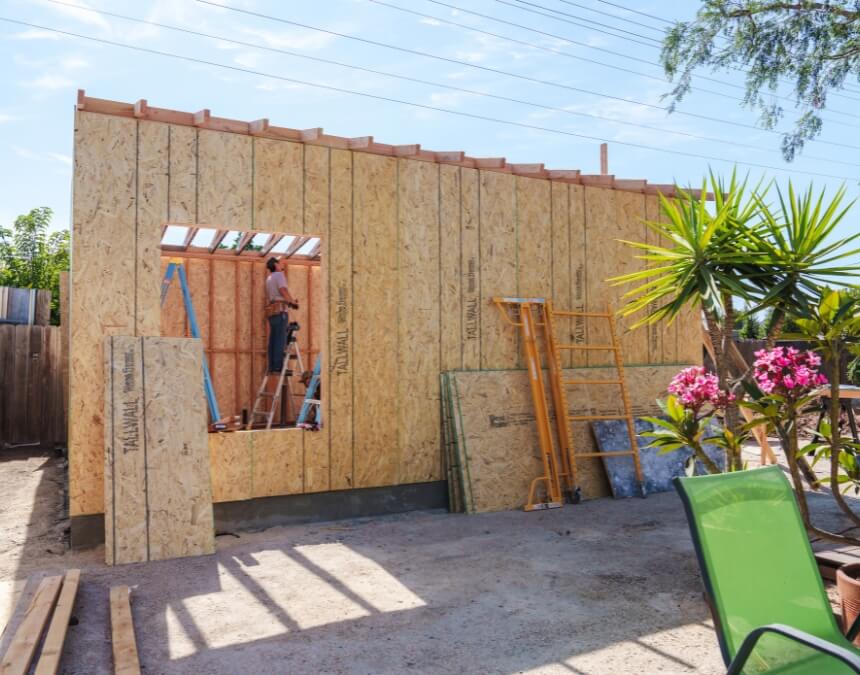 Benefits of Downsizing to an ADU wood-framed ADU under construction in backyard