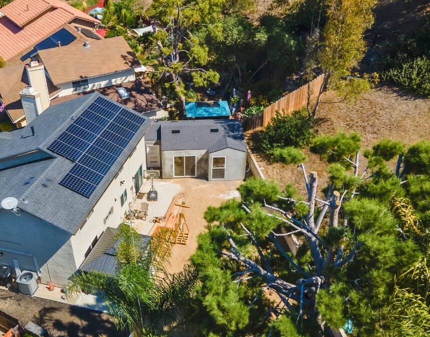 “Factors Influencing Survey Decisions” aerial of a property with a detached ADU and surrounding trees, indicating terrain and boundary variables.