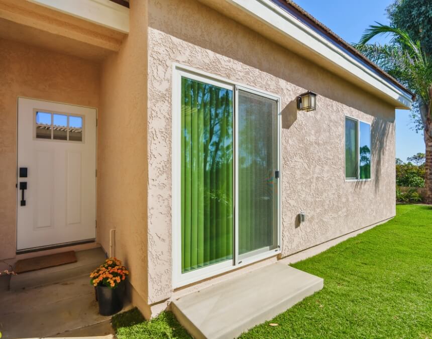 “Licenses & Legal Compliance (California + San Diego)” image of a finished stucco ADU exterior with sliding door and clean concrete landing.
