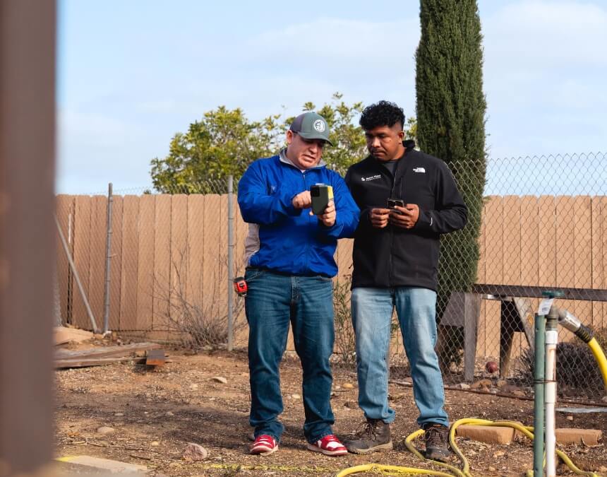 Professionals Involved in ADU Survey Decisions – survey professional and project team reviewing site measurements on a San Diego property before ADU planning.