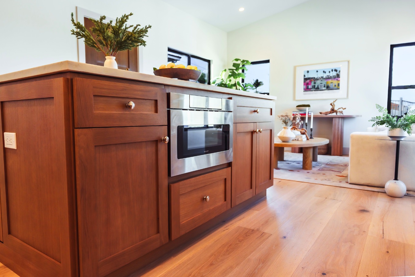 Close view of the kitchen island in the Linda Vista Detached ADU featuring built-in microwave storage, wood cabinetry, and a decorative centerpiece.