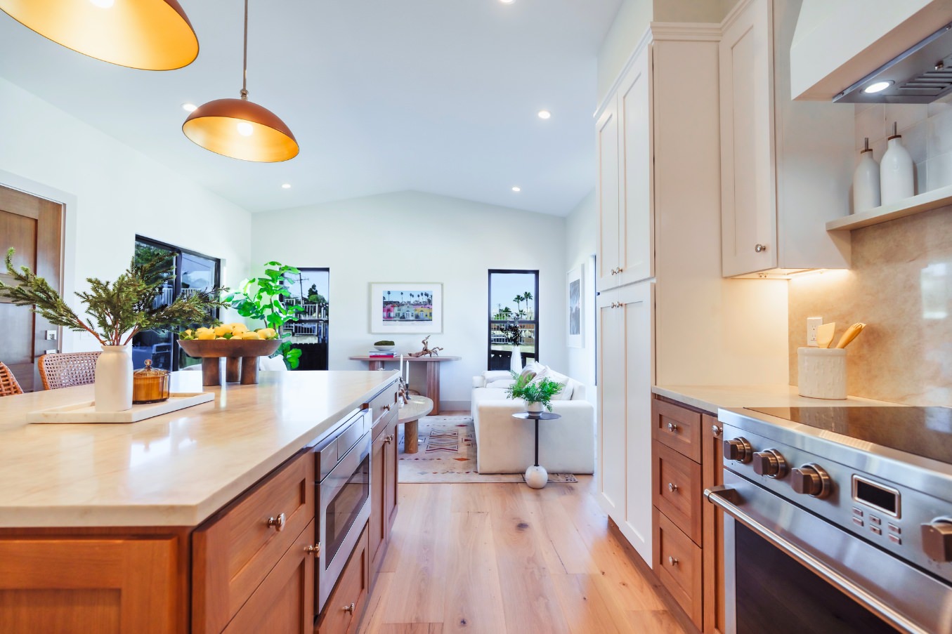 Perspective from the kitchen island looking into the living room of the Linda Vista Detached ADU, highlighting pendant lighting, seating, and open layout.